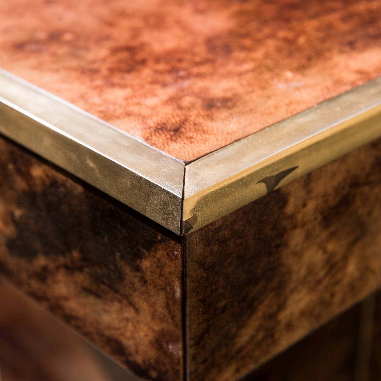 Brown parchment veneered office desk by Aldo Tura.
It is brass trimmed with a row of three drawers.