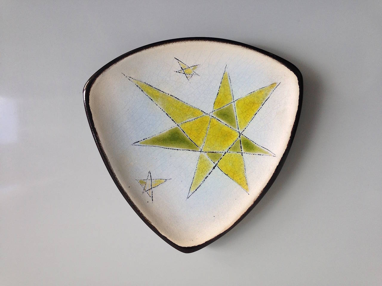Denise Gatard 1927-1992)

This larger shell is matt white yellow green enameled on the inside and with a shiny black/brown glaze outside. The motiv is in a form of a 