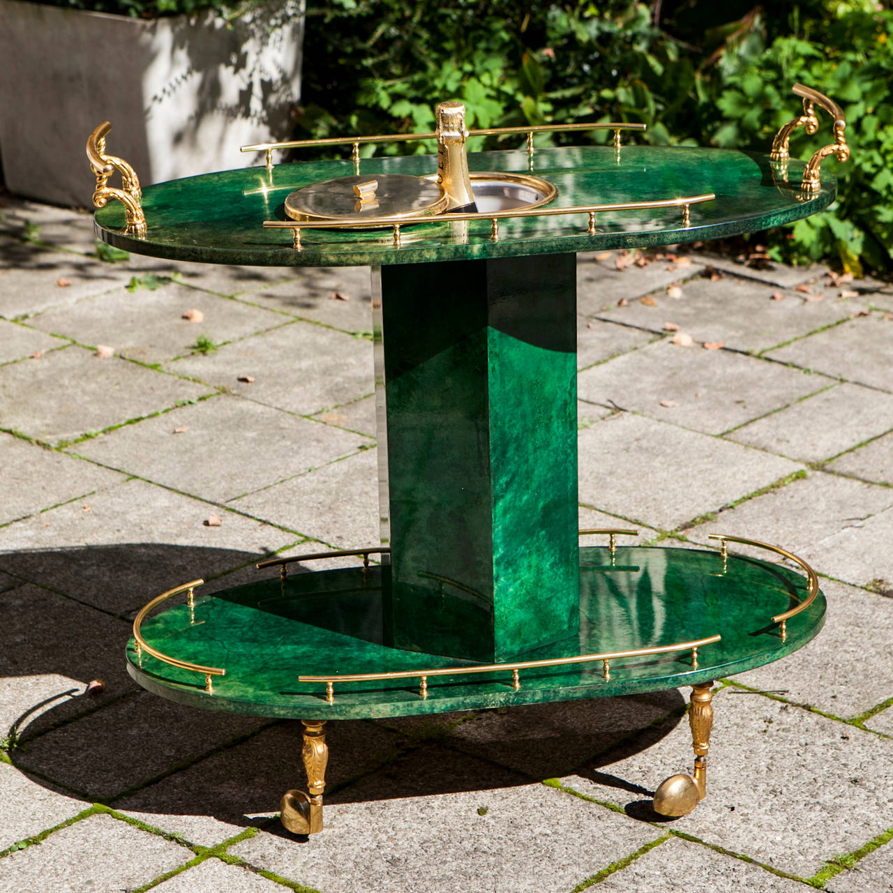 A bar cart by Aldo Tura, Milano, Italy in green lacquered goatskin with a cooler for champagne bottles, with brass details.