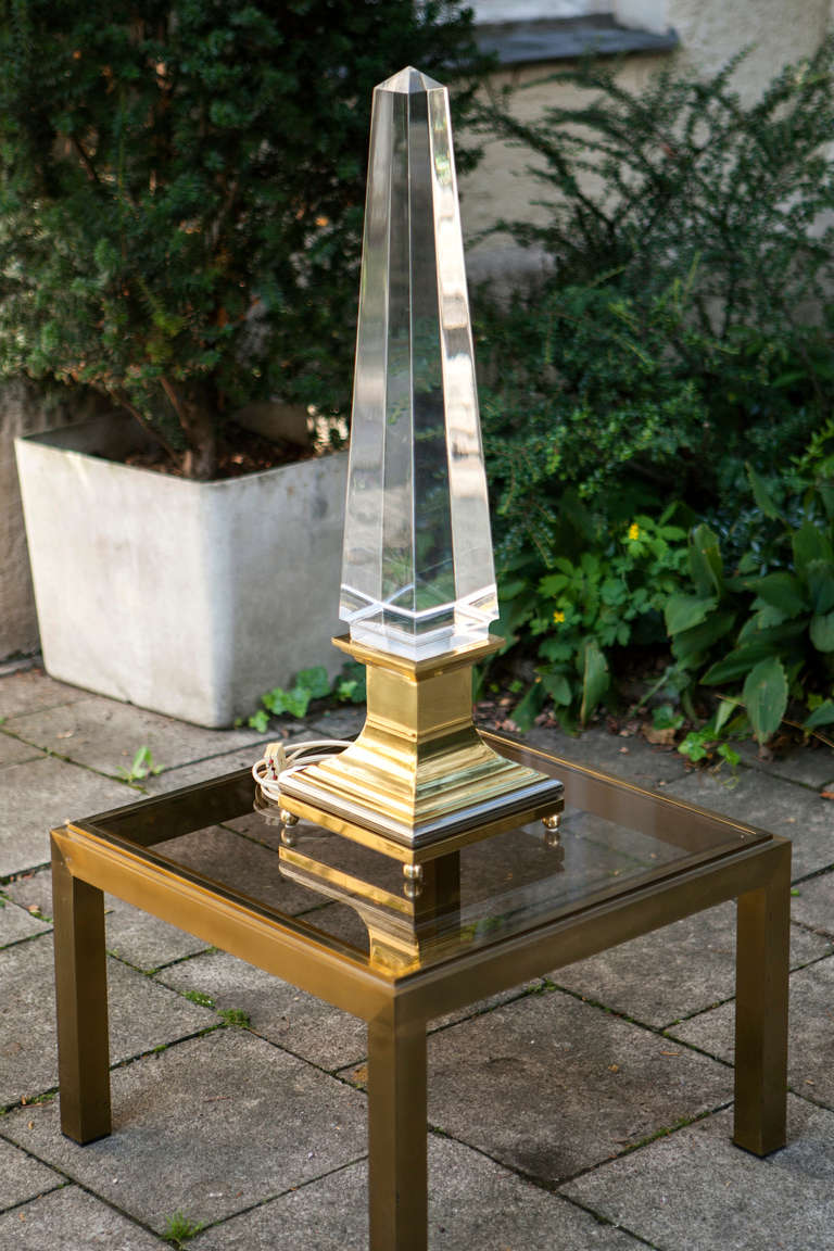 The Obelisk Lamp was designed in the 1970s by Sandro Petti for Maison Jansen. The obelisk is made from lucite and the base is made from chromed metal and brass.