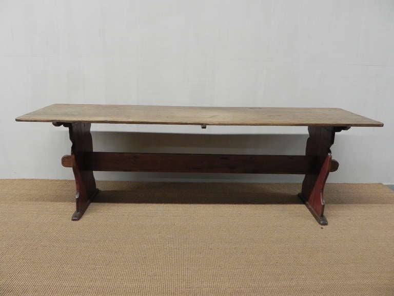 A wonderfully understated farm table in the Gustavian tradition. This scrub top trestle table has the original paint to the base. Patinated and softened in form by years of use and scrubbing, it has taken on a lovely colour to the pine.