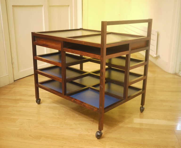 A rare serving trolley designed by Bodil Kjaer for her apartment in 1959. Solid rosewood and rosewood veneer, bleu formica, on castors and stainless steel hot plat. Hidden box. Fully original.