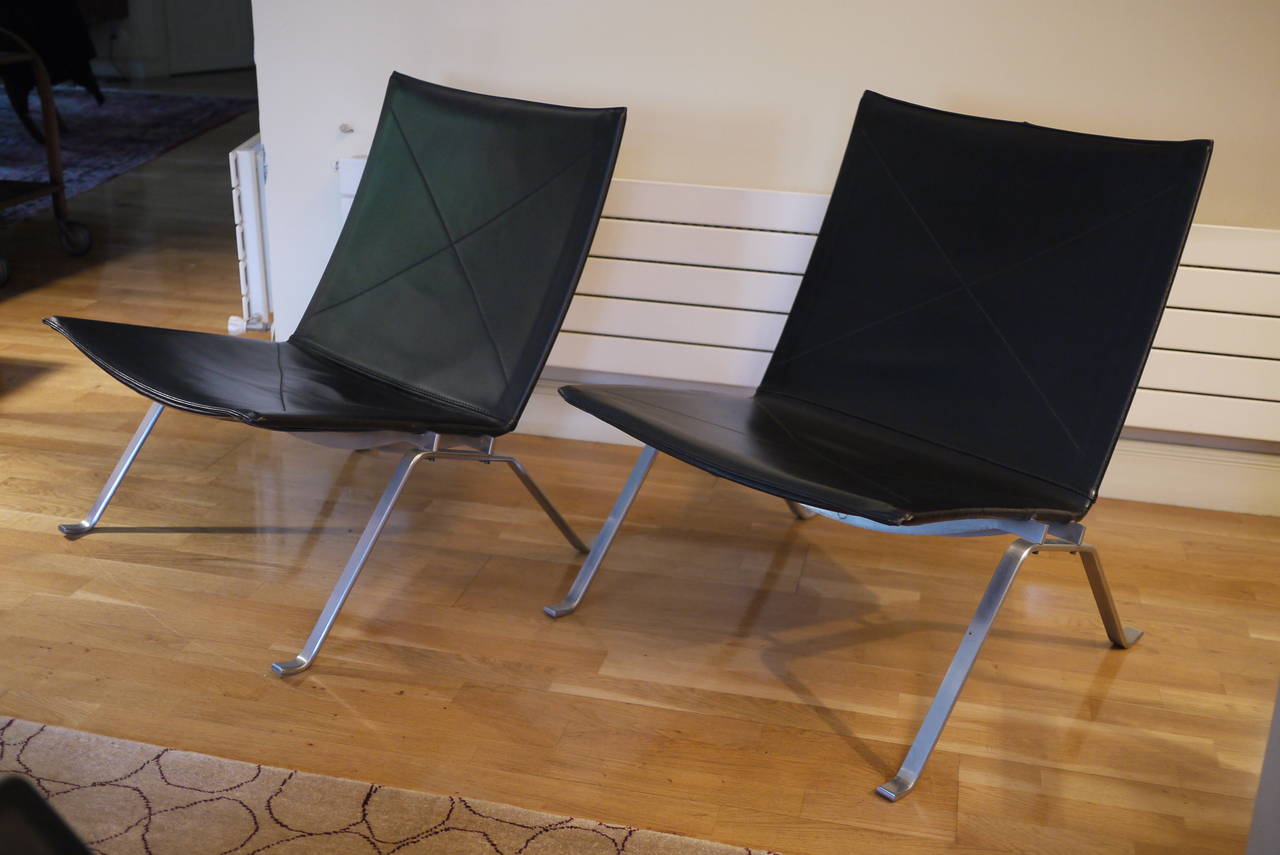 Two PK 22 Lounge chairs designed by Poul Kjaerholm for Fritz Hansen.Brushed steel frame and black patinated leather.