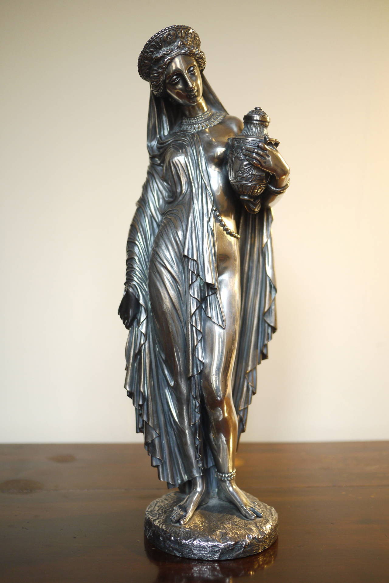 A fine French silvered bronze of Pandora by Jean-Jacques Pradier, the maiden shown standing, partially draped and richly bejewelled , a relief-cast urn in her left hand, signed Pradier Scpt and inscribed E. de Labroue . Mid 19th Century.
Pradier's