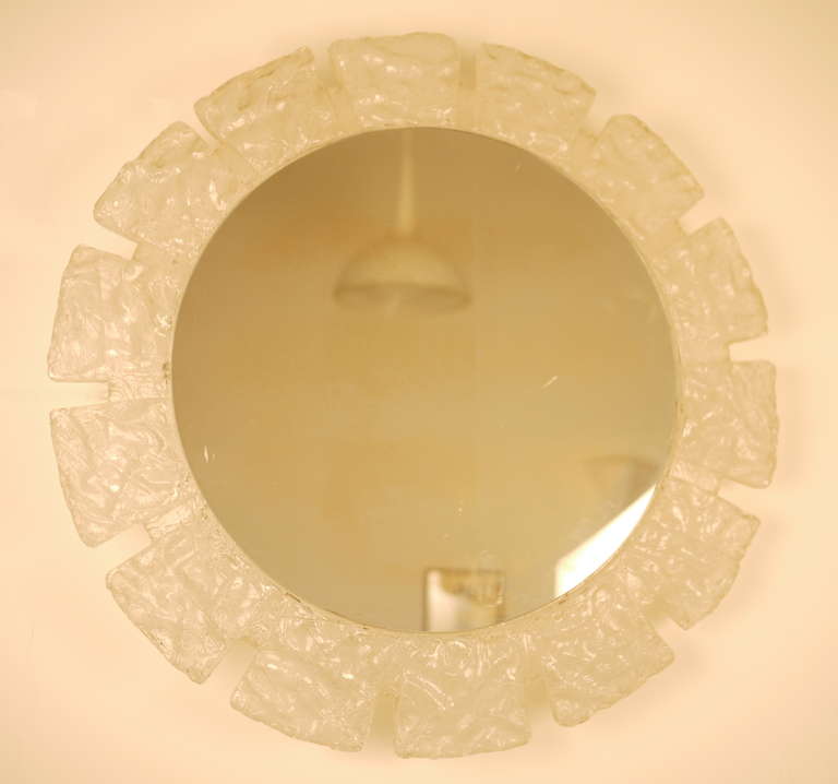 A German illuminated resine /perspex circular mirror edited in the 70s.Textured frame with deep sawtooth edge.