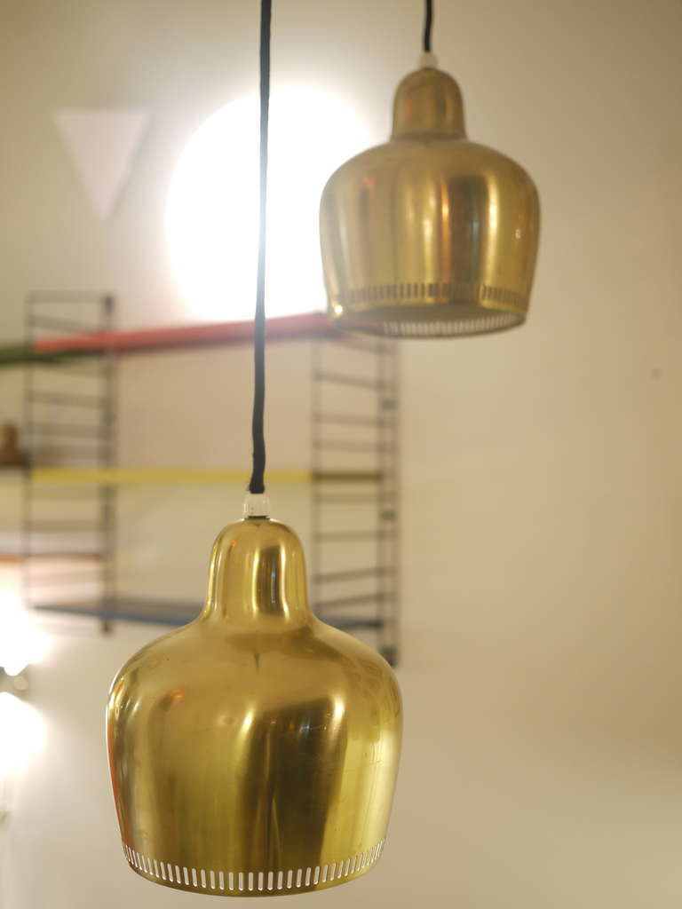 A pair of 1960s Alvar Aalto Golden LIghts .Designed in 1937 and made from a single piece of brass with a lower perforated ring to create a luminous crown.