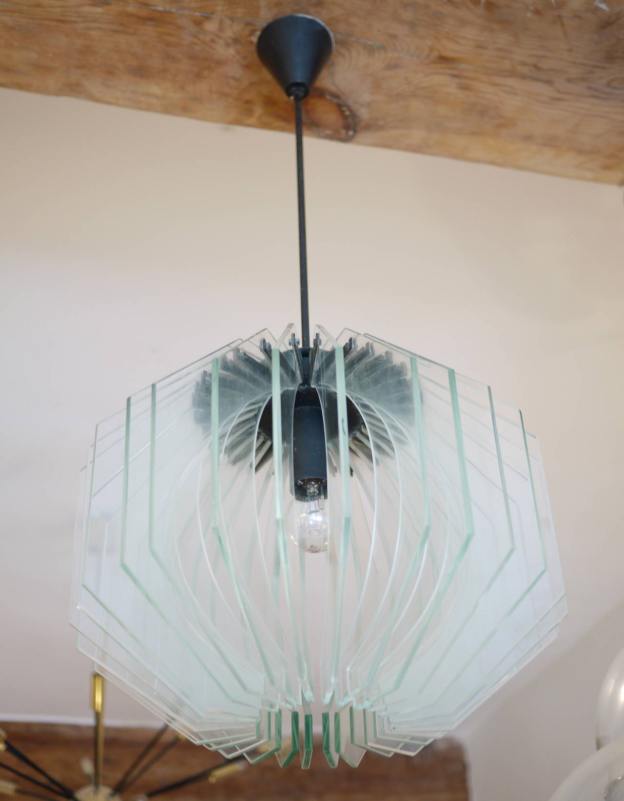 A 1960 Max Ingrand Chandelier. Crystal-cut glass and varnished metal. Bibliography: Vitrum nº 125 ,May-June 1961.