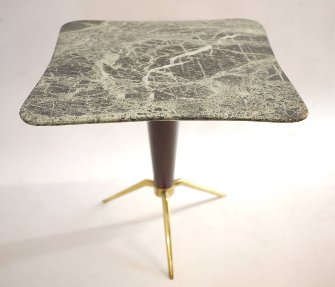 A 1950 Italian coffee table .Lacquered wood ,marble and brass legs.