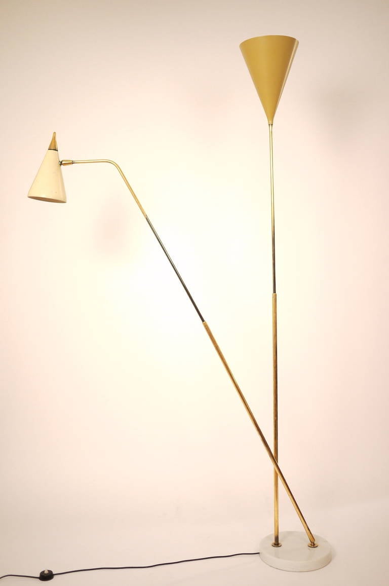 An adjustable floor lamp designed by Giuseppe Ostuni and edited by O'Luce, circa 1950.The lamp is a rare variation of model 339-2PX, having two enameled aluminum shades supported by two adjustable brass arms on a polished marble base. Measures: One