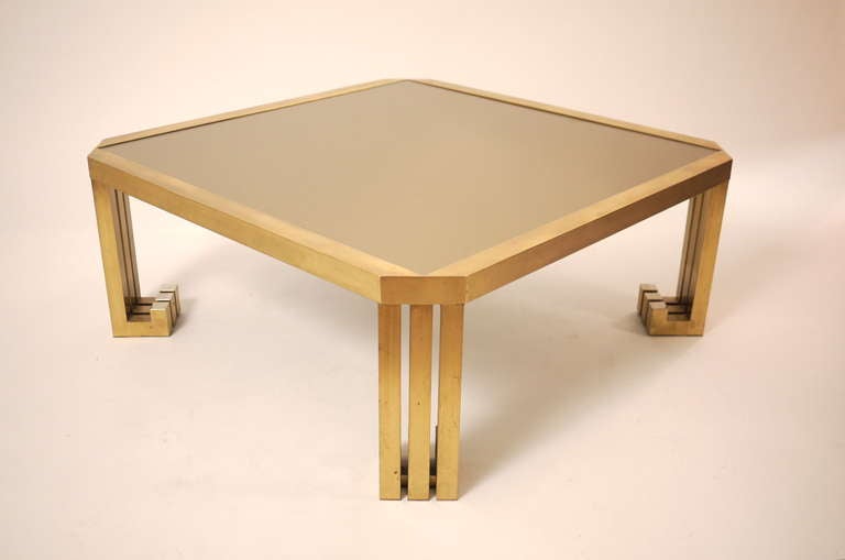 A rare  brass and golden glass French coffee table with claw brass legs .