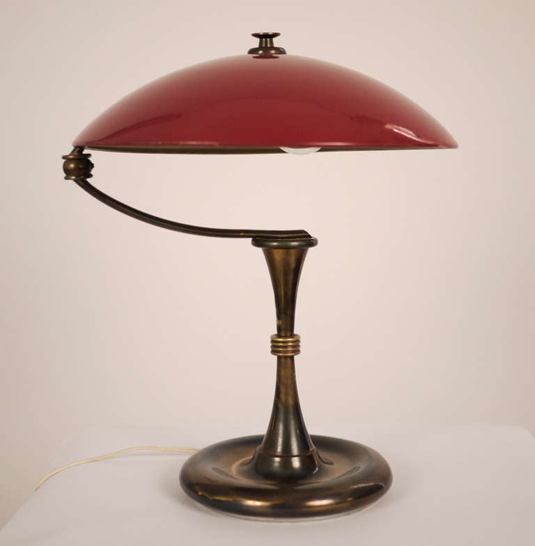 A Swedish table lamp , produced in 1950s .Brass and  enameled aluminum . Adjustable arm .