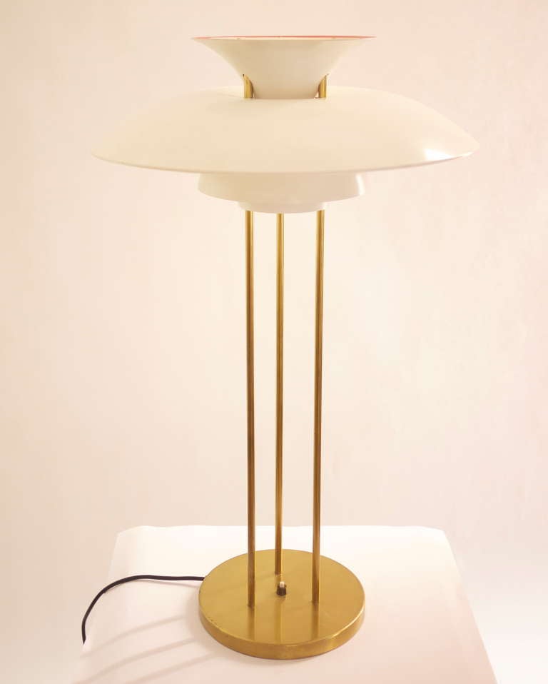 A PH5 table lamp designed by Poul Henningsen in 1927 and edited by Louis Poulsen in 1970s .Three brass legs ,brass base and white painted metal shades. Impeccable conditions . No longer produced.