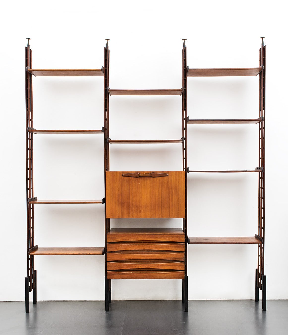 An Italian 1950s rosewood bookshelf system. Massif rosewood and brass fittings. Adjustable height from 275 cm to 320 cm, the bookcase includes two storage units: one bar cabinet and one drawer. Both are shown in image 3. Excellent condition.