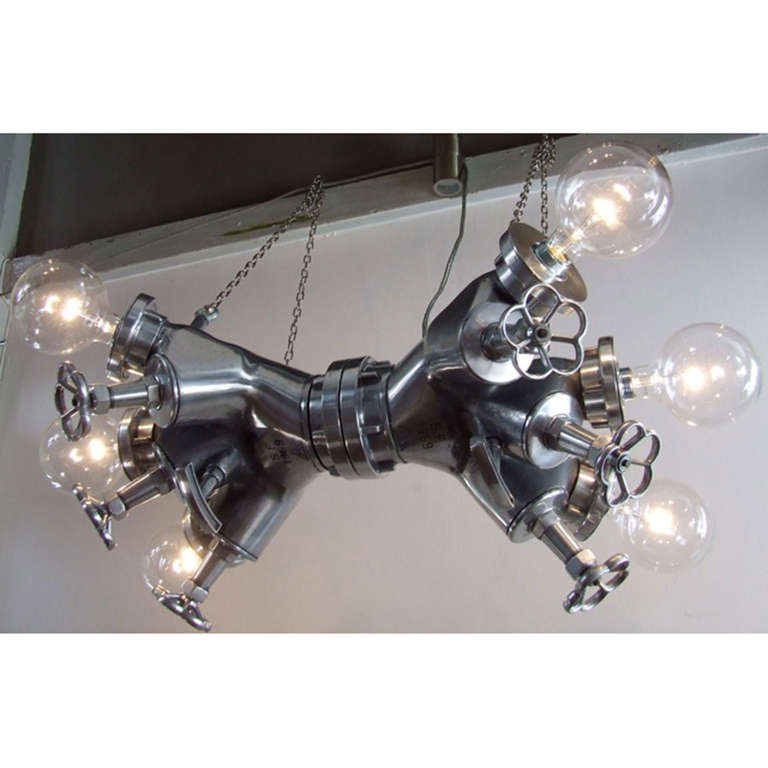 This impressive polished aluminum firehose manifold has been redesigned into a chandelier by Dutch designer Stef van der Bijl. This fire hose manifold probably comes from the San Fransico Fire department, build in 1969. The initials S.F. 1969 are