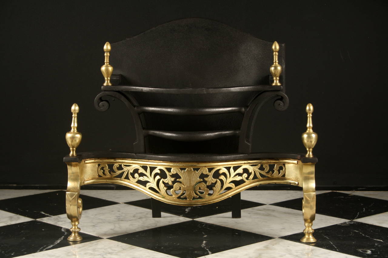 An English cast iron and etched brass bow fronted firegrate in the Rococo manner, with an arched back and a pierced serpentine apron engraved with foliage and shaped legs with brass finials above, English late 19th century.

Depth: 12
