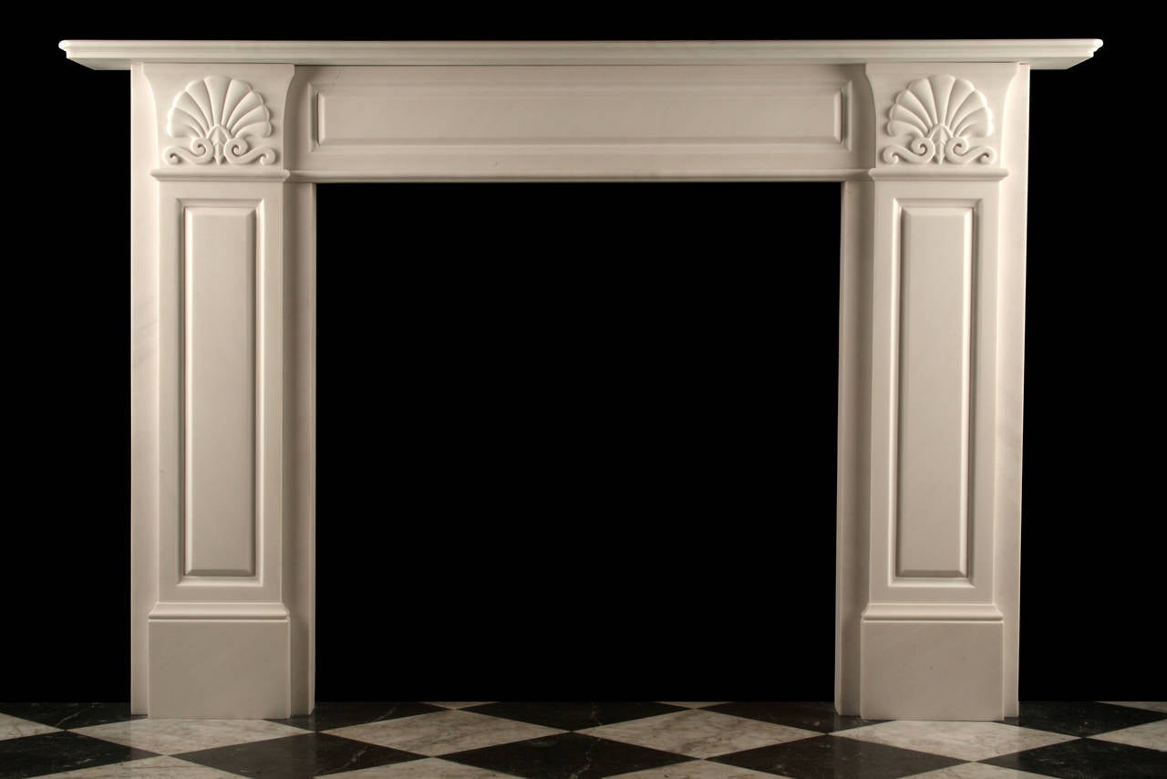 A Grand Regency Fireplace Mantel in High Quality Italian white Statuary Marble, with very finely carved endblocks and panelled columns and cross-section, in the English early-19th Century Style, produced by us in London with the finest quality