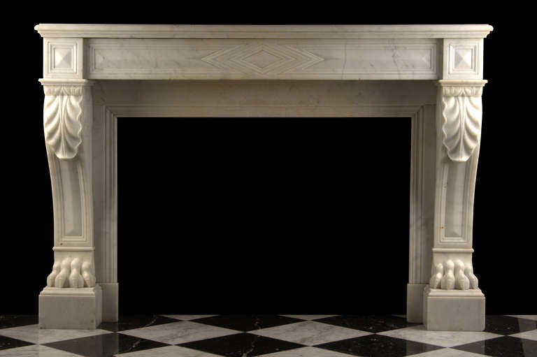 A well proportioned Antique Louis XVI Fireplace Mantel finely carved in lightly veined White Statuary marble, with acanthus leaf carved scrolled tops and richly carved Lion Paw feet, French mid 19th Century.