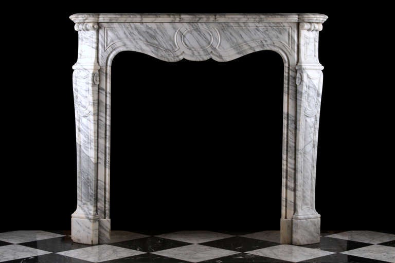 A Louis XV Pompadour Antique Chimneypiece very finely carved in elegantly veined Arabescato marble, with a serpentine shelf over the finely carved panelled frieze and decoratively carved jambs, French Circa 1870.

Depth: 14 1/2” - 37 cm 
External