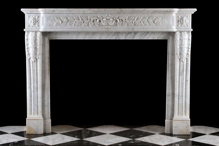 A very attractive French Louis XVI Chimneypiece nicely carved in White Carrara marble. The shaped frieze finely carved with oak leaf and acorn decoration. The jambs very finely carved with acanthus leaves and carved beading moulding scrolling to