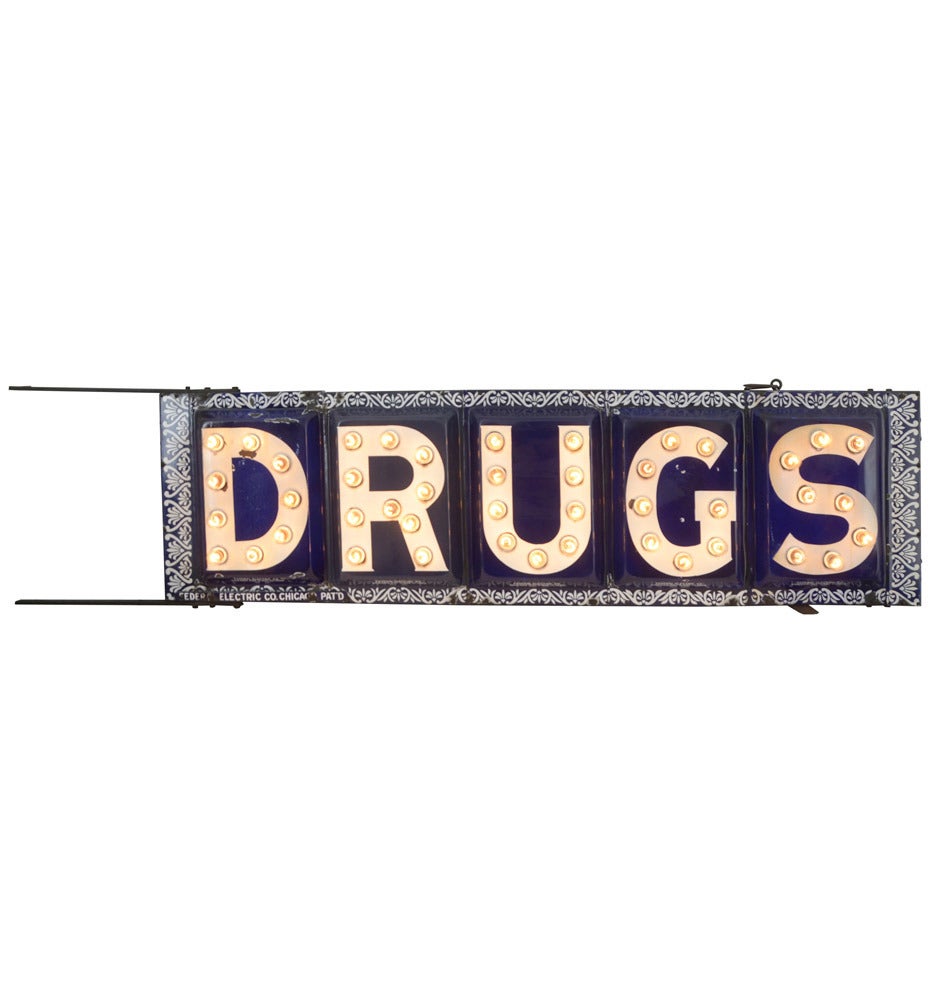 We took special care in restoring this incredible early-century pharmacy DRUGS sign. Always fans of porcelain enamel, we are fascinated by the ornate blue and white frame and the 18" tall pressed enamel letters, each of which is adorned by a