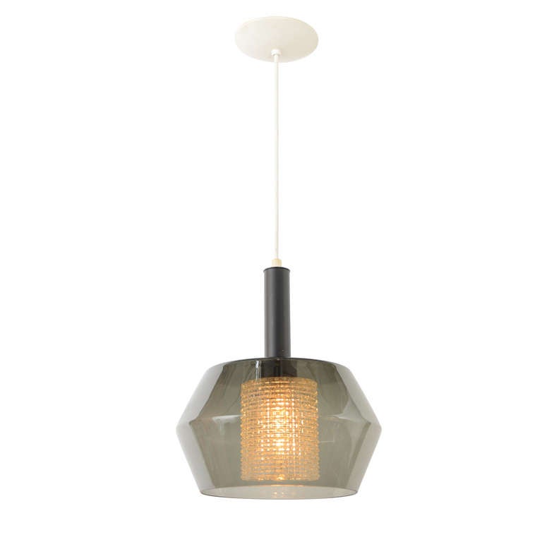 Another Mod or Contemporary pendant that updates classic midcentury styling of the 1950s and 1960s with a modern sculptural shade form and the dual-glass combination of clear smoky topaz and a highly textured clear pressed glass cylinder. Simple yet