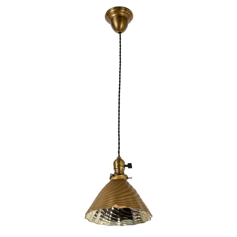 This simple and classic drop-cord pendant has been outfitted with an outstanding silvered X-ray reflector shade featuring bold spiral corrugations, subtle edge crimping and the original gold exterior some with brand decal. Some of the paint on the