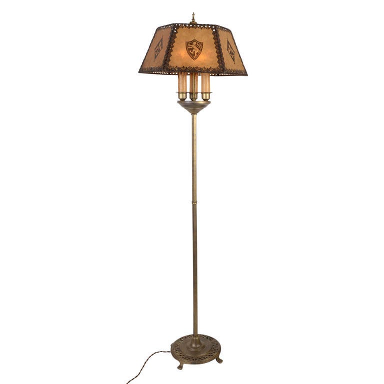 With decorative elements from several style periods including Classical, Gothic and Mission, this impressive floor lamp is a fantastic representation of Historic Revival lighting. While the resin parchment shade features English and French Heraldic