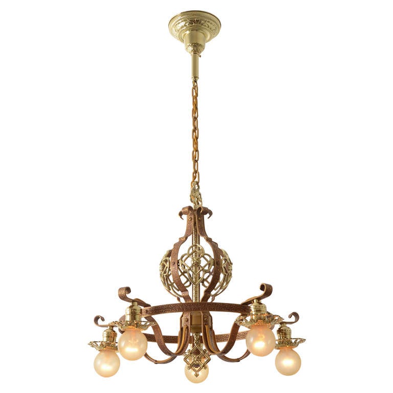 This classic late 1920s, five light chandelier enhances its finely cast details with an antique gilt painted finish and bright brass accents that add character and gentle beauty. A fixture like this one would be right at home in one of the countless