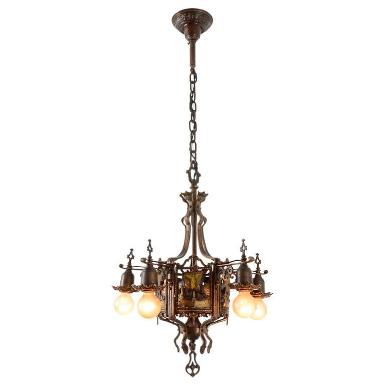 In the realm of heraldic chandeliers, this one takes the cake. With all original polychrome and intricate cast relief, it's hard to imagine a more dramatic light. Our favorite detail is found in the five panels between the arms, featuring a