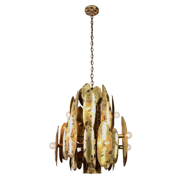 This more restrained torch-cut chandelier is evocative of the look popularized by Tom Greene in a series striking fixture designs produced for several different lighting companies in the late 1960s and early 1970s. Less aggressively cut, with fewer