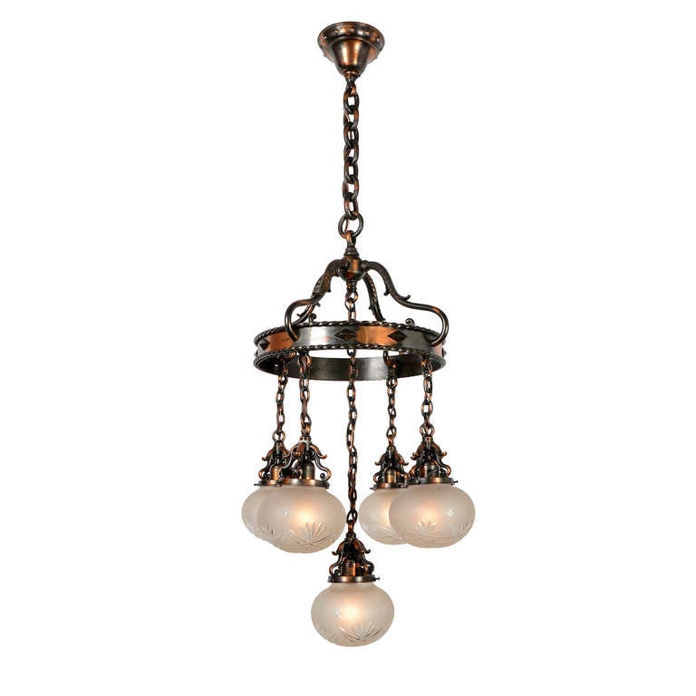 A great example of how period fixture designs often refuse to be easily pigeon-holed into style categories, this stunning chandelier combines touches of Classical Revival, Old English, and Craftsman styles.  The suspended-ring shower was at the
