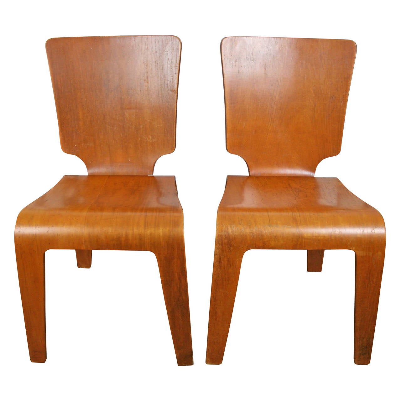 Like Charles Eames, Herbert Von Thaden began experimenting with molded plywood as a military resource during World War II. These handsome side chairs were an unexpected result. Made from bent plywood and veneered in amber-colored maple, this pair