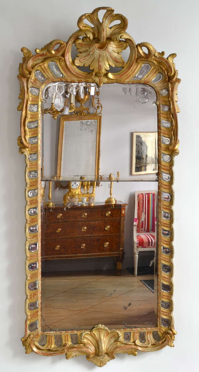 A swedish rococo mirror made around 1760 in Stockholm. Not signed but certainly made by Ehrhardt Göbel (1690-1764). The small kidneyshaped glasspieces beside the large pierglass are typical for his work. So is also the rocaille at the top of the