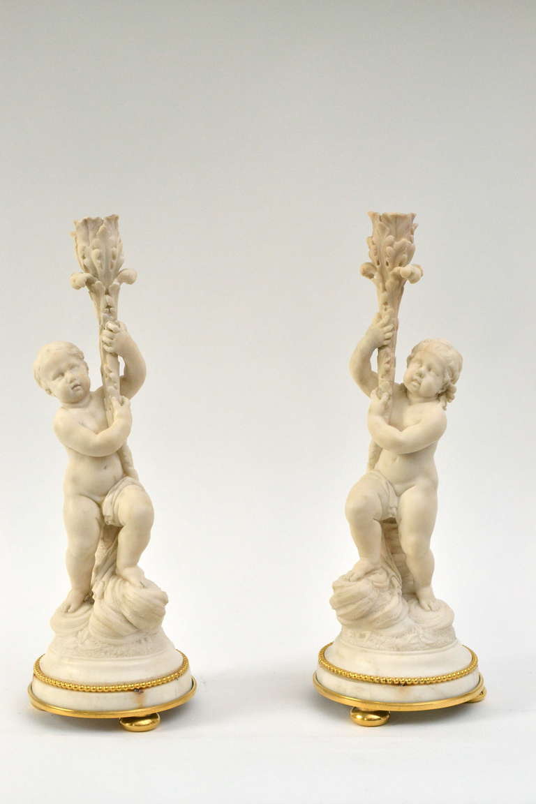 Pair of unusual Louis XVI sculptured white marble candlesticks with gilt bronze mounts, 18th century. Italian or French. 