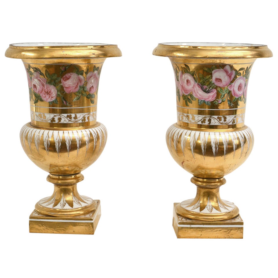 A pair of French porcelain gold-ground and flower painted vases on white marble bases, circa 1825.