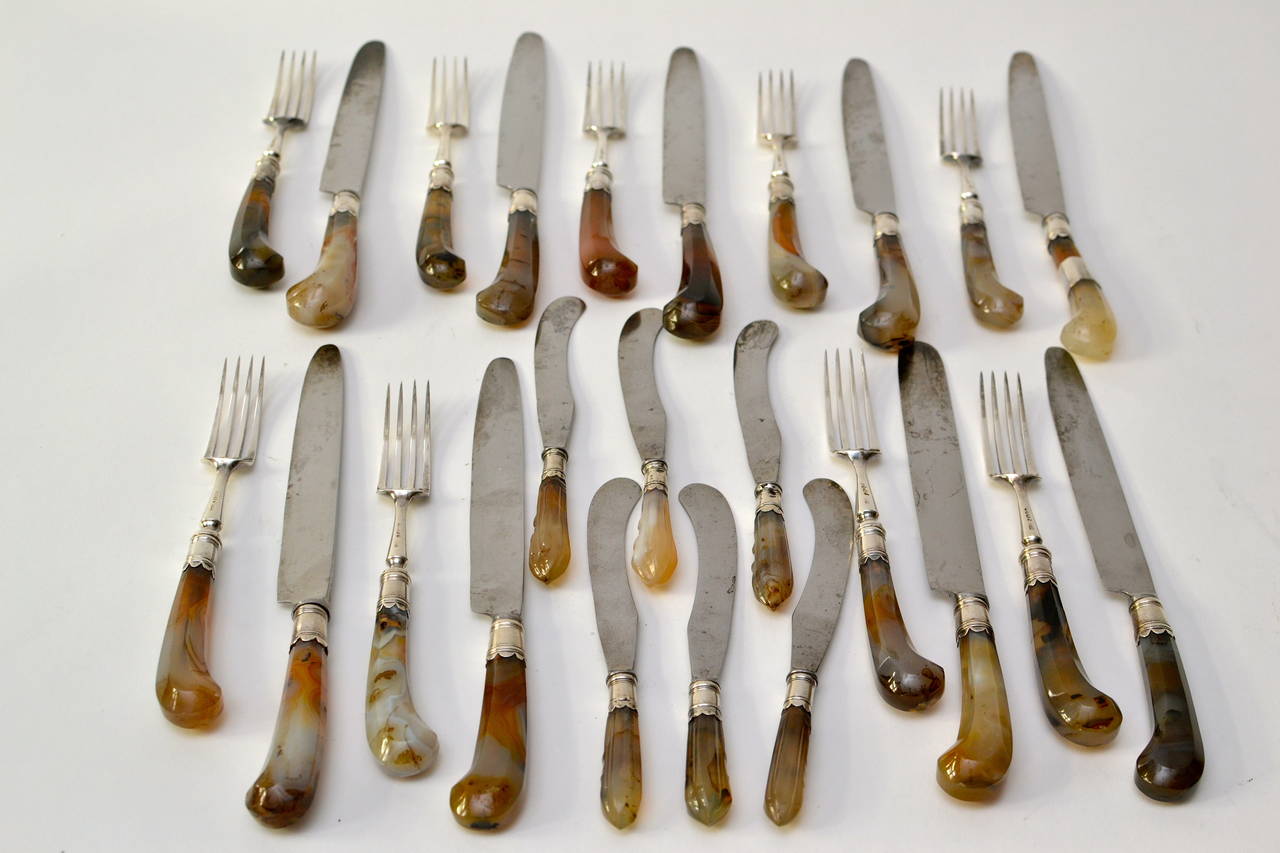 English set of 18 agate handled knives and forks together with six fruit knives. The silver stamped Henry Crowder, London, 1833. The agate handles possibly 18th century. The steel blades on knives.