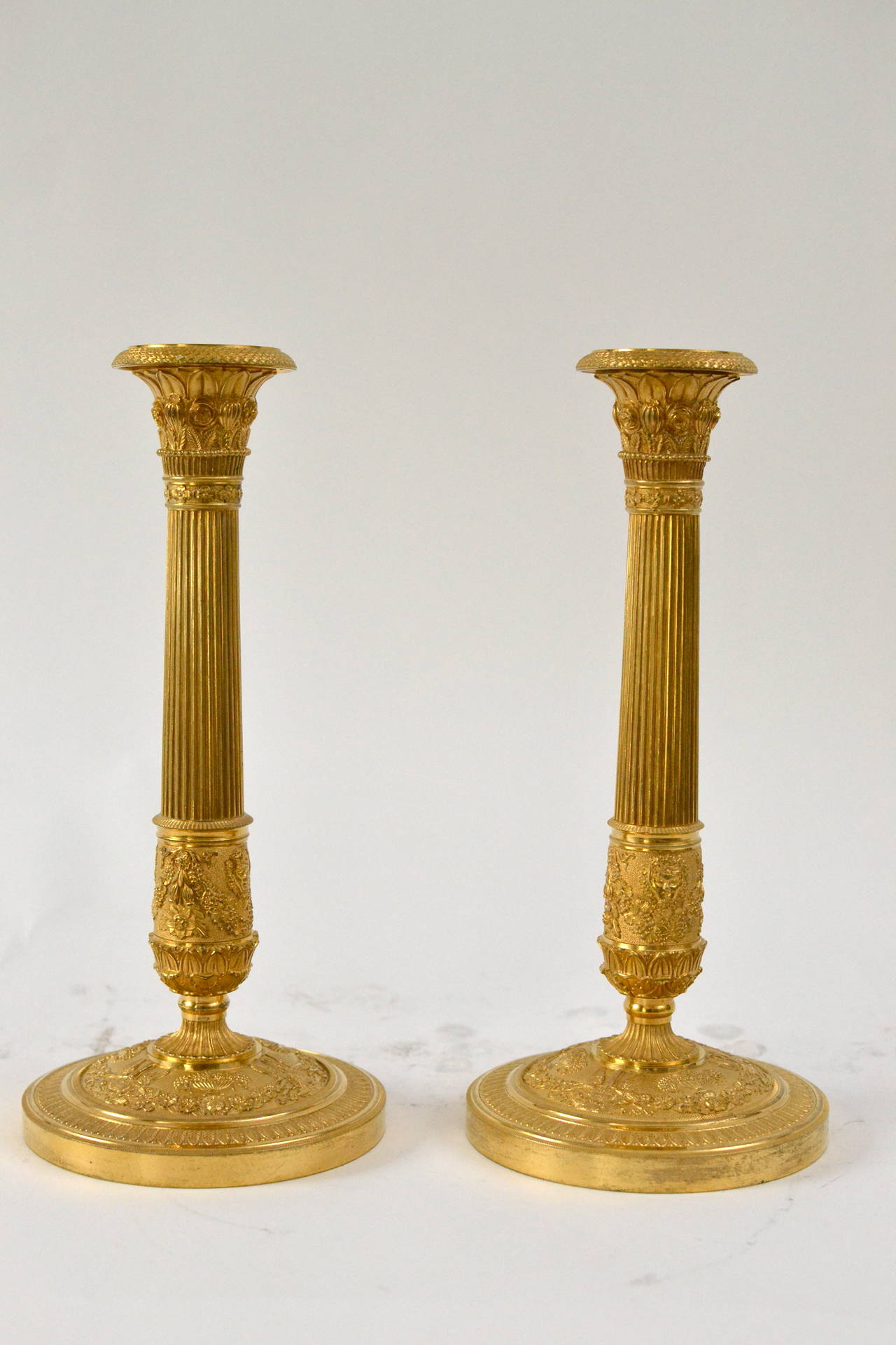 A pair of French Empire gilt bronze candlesticks, early 19th century.