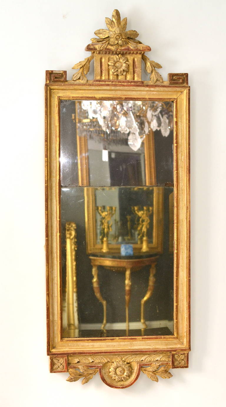 A Gustavian carved giltwood mirror attributed to Joseph Schürer, (1727-1785) with the mirrors guild mark Stockholm 177. The gilding in worn original state.