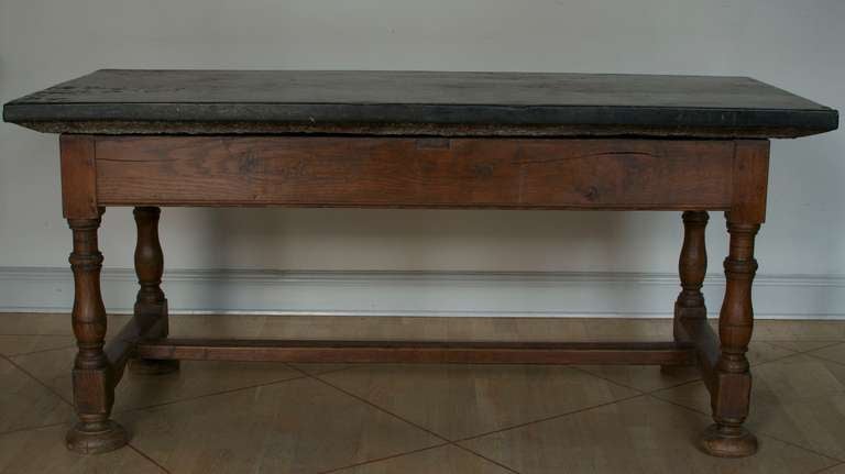 A large Swedish stone slab table, 18th/ 19th cent. Made in the south of Sweden with a baroque stand. The stone slab is “Komsta sten” marble, a Swedish type of grey/blackish limestone, with fossils visable on the surface.