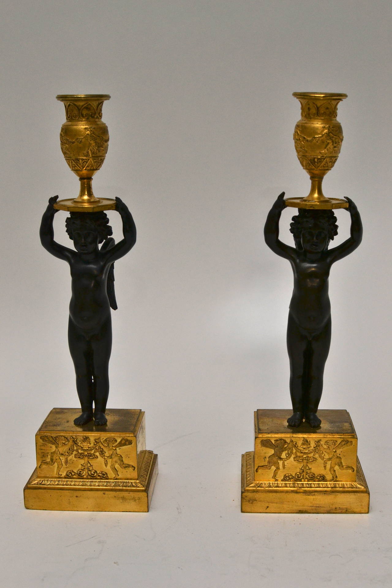 A rare pair of Russian empire gilt and patinated bronze candle sticks, circa 1810.