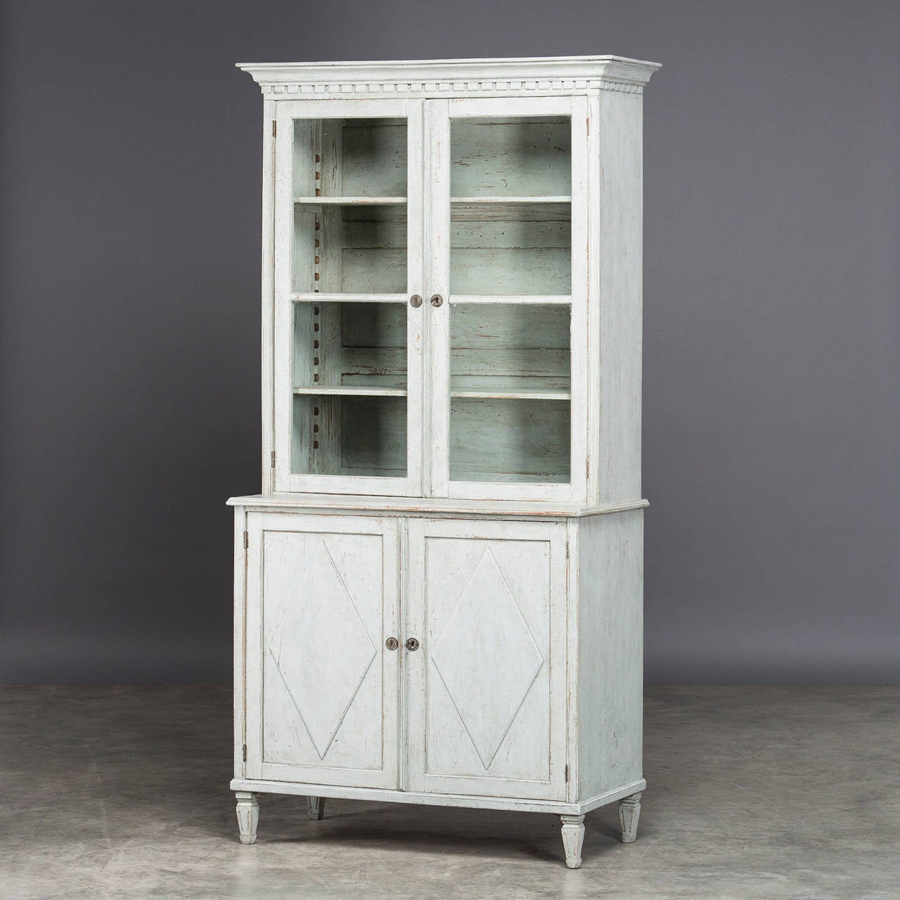 Showcase in Gustavian style. Upper part with a pair of doors with glass, base with a pair of doors with panels in the form of diamonds. Sweden 1840-1860 - Good patina. The cabinet is in 2 parts.