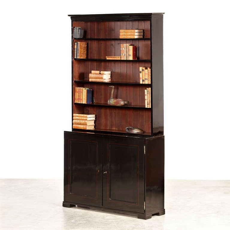 Ebonized Empire bookcase. Upper part with shelves and lower part with doors.
Filling veneered with light wood.
Copenhagen, circa 1810.