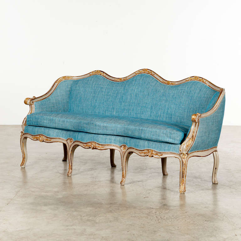 Elegant danish Rococo sofa with curved back and bending legs. Carvings with giltwood. 
Upholstered with fabric from Osborne & Little. 
Copenhagen, c. 1770.