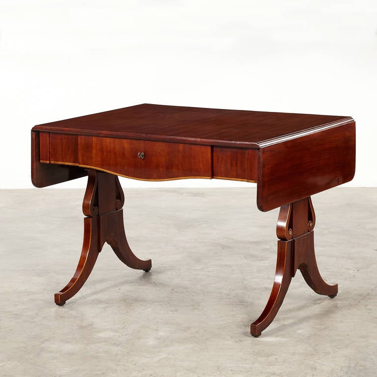 Beautiful Empire desk with leafs (each 25 cm) and drawer. Free standing. Crafted in Cuban Mahogany. Pale intarsia molding in the frame and the shaped legs. 
Copenhagen, c. 1810.