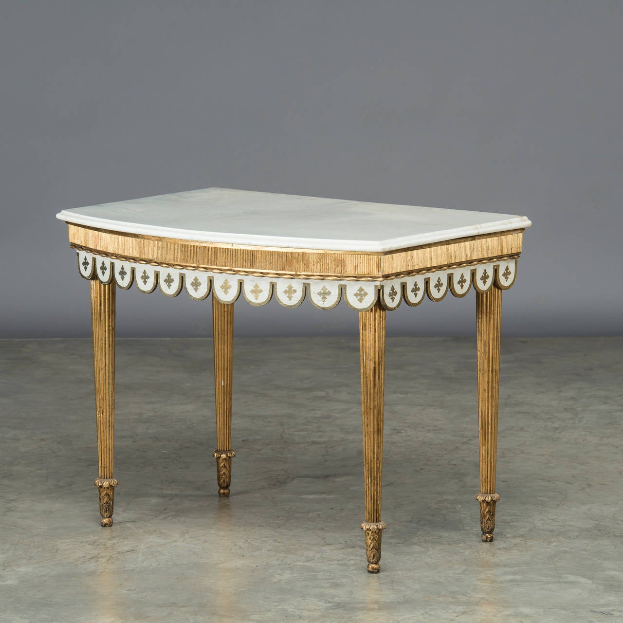Louis XVI console table with beautiful white marble top with profiled edge. Legs and frame in gilded wood with grooves. Below the frame, half-rounded wood carvings with gilded fleur-de-lis, Denmark, circa 1780.
