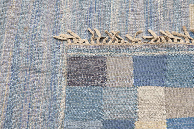 Flat-woven Swedish rölakan rug in mainly blue tones. No design in the centre, only horizontal various in blue tones. Woven by Bohusslöjd in Gothenburg. Unknown designer. Signed: B.