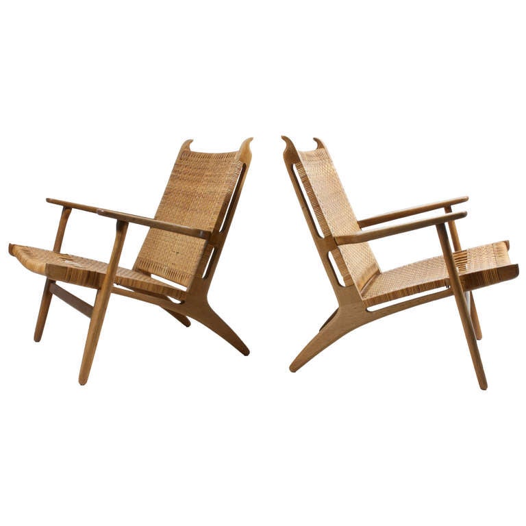 A beautiful pair of original patinated oak easy chairs with woven cane seat and back. 

Designed by Hans J. Wegner and manufactured by Carl Hansen & Son, model CH27. 

The chairs appear in fine original condition with minor signs of age.