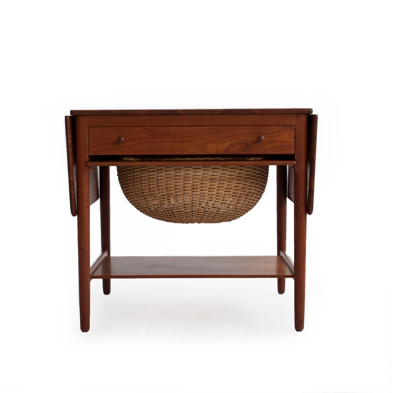 Hans J. Wegner sewing table in teak with two drop-leaves, front drawer and a woven cane basket.

Designed by Hans J. Wegner, 1950, manufactured and marked by cabinetmaker Andreas Tuck, model AT33.

Excellent condition.