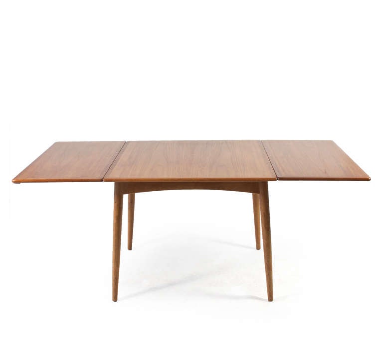 A beautiful square drop leave dining table by Hans J. Wegner. 

86 x 86 cm, leaves of each 46 cm - when both leaves are up the tables measures 178 cm in length. 

Table top and two detachable drop leaves of teak. Frame and legs of patinated oak.