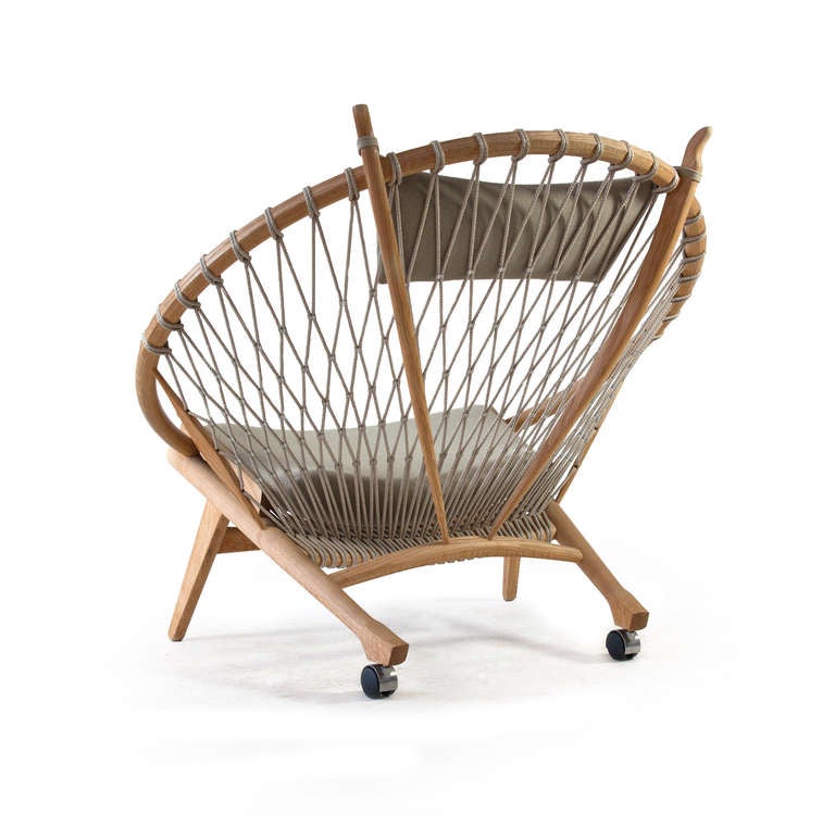 The Circle Chair by Hans J. Wegner 

Frame of ash, back with braided flag halyard, seat and neck cushion upholstered with grey-green fabric and hind legs with casters. 

Designed by Hans J. Wegner for PP Mobler in 1985, as model PP 130. 

Fine